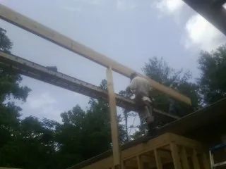 Carpenter setting a ridge beam over a new addition frame — Ice Dam Removal by Roofing Brothers in Allen Park