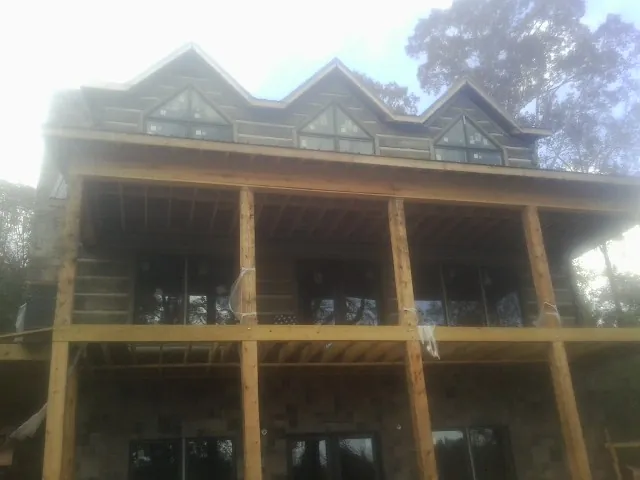 Dormers and porch framing on a large log home under construction — Roof Coating work by our crew in Allen Park