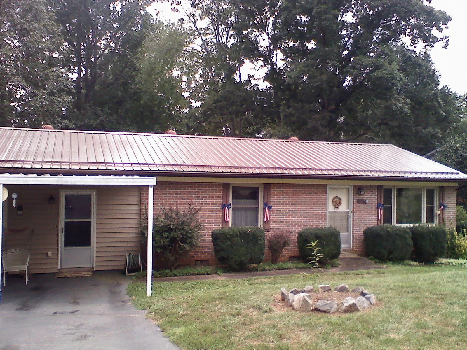 Bronze metal roof and carport on a brick ranch home — Roof Repair work by our crew in Allen Park